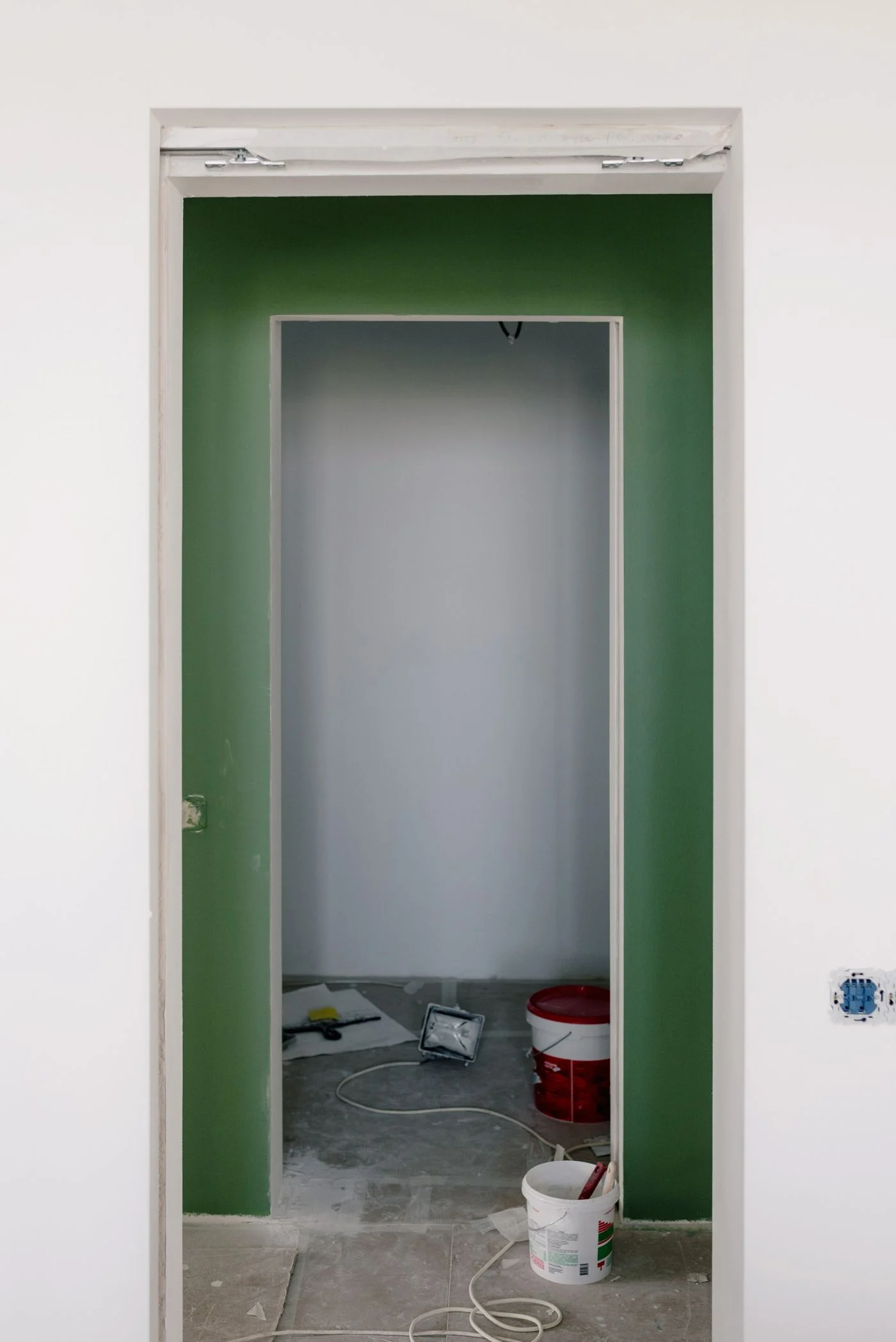 Freshly painted room with green wall and painting supplies. — illustrative photograph.